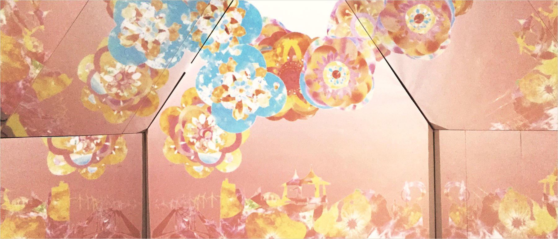 Inside the Flora Expo pavilion: mirrored walls and ceiling covered with projected pink, yellow and blue mandalas above a skyline of temple roofs