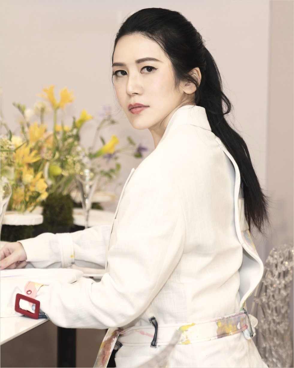 Ku Chi-Chun in a white suit at a flower-laid table